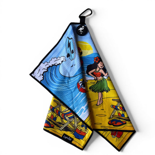 The Beach Party Golf Towel (24” x 16”) features a colorful design with a hula dancer, surfboards, waves, and palm trees. This premium microfiber towel includes black trim, a magnetic clip, carabiner, and flamingo logo hanging loop.