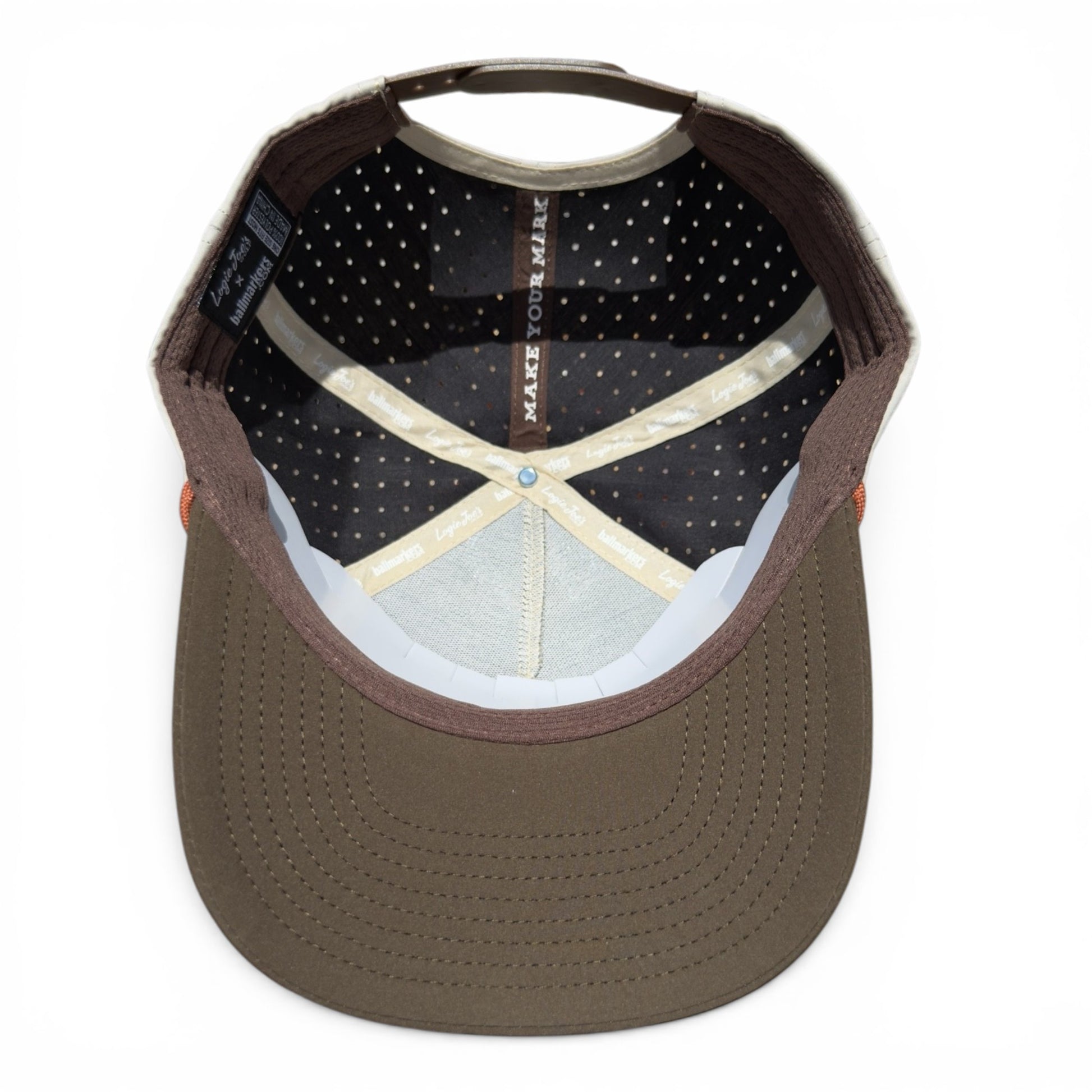 Top view of the Longhorn Golf Hat | Snapback Cap with light blue inner lining, beige fabric tape, black mesh with white dots, and “MAKE YOUR MARK” on a black strip. Features a built-in magnetic ball marker holder and adjustable tan bull skull design.