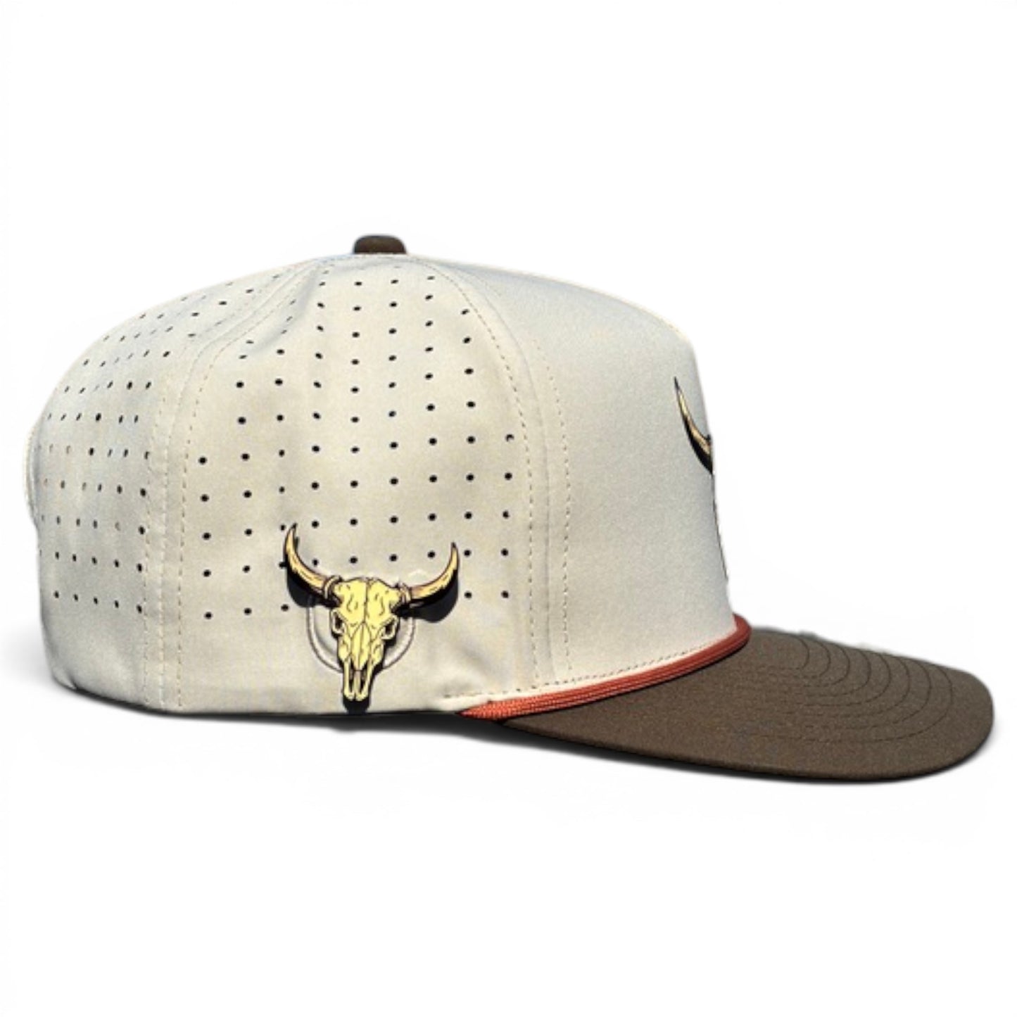 The Longhorn Golf Hat is a beige and brown snapback cap with an adjustable fit, featuring a tan bull skull emblem, perforated side design, red trim above the brim, and includes a built-in magnetic ball marker holder with marker. Perfect for golf enthusiasts.