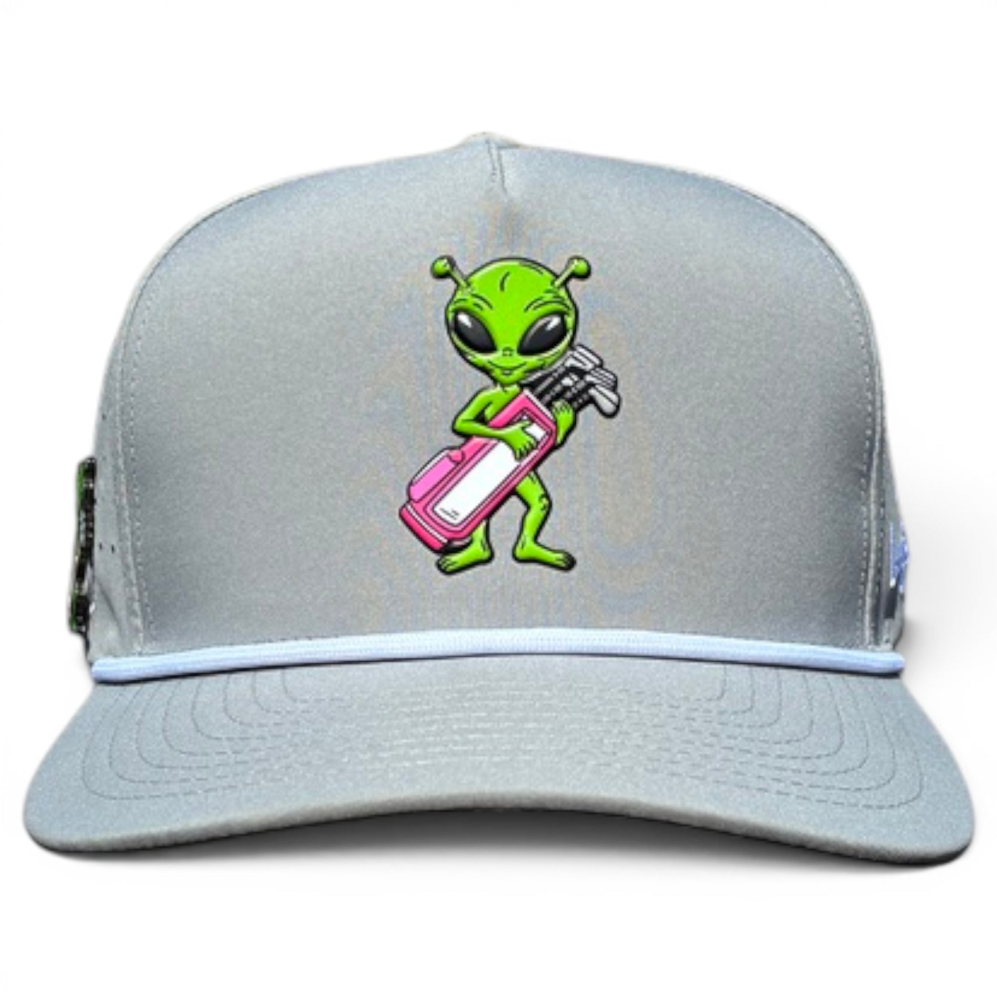 The Alien Caddy Golf Hat is a light gray adjustable snapback cap featuring a green cartoon alien with a pink and white golf bag on the front. It includes a built-in magnetic ball marker holder plus marker for added convenience.