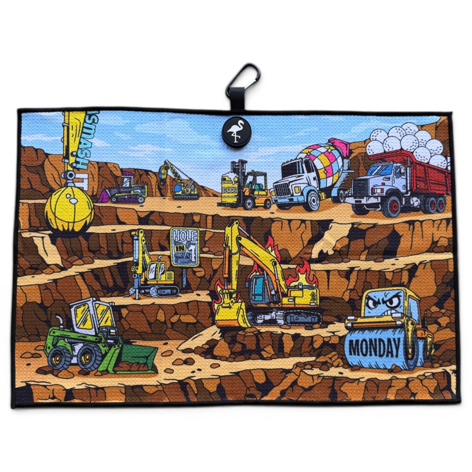 The Wrecking Crew Golf Towel is a 24” x 16” illustrated microfiber towel with cartoon vehicles like excavators, bulldozers, a cement mixer, and a MONDAY-labeled dump truck working in a layered pit. Includes magnetic clip & carabiner.