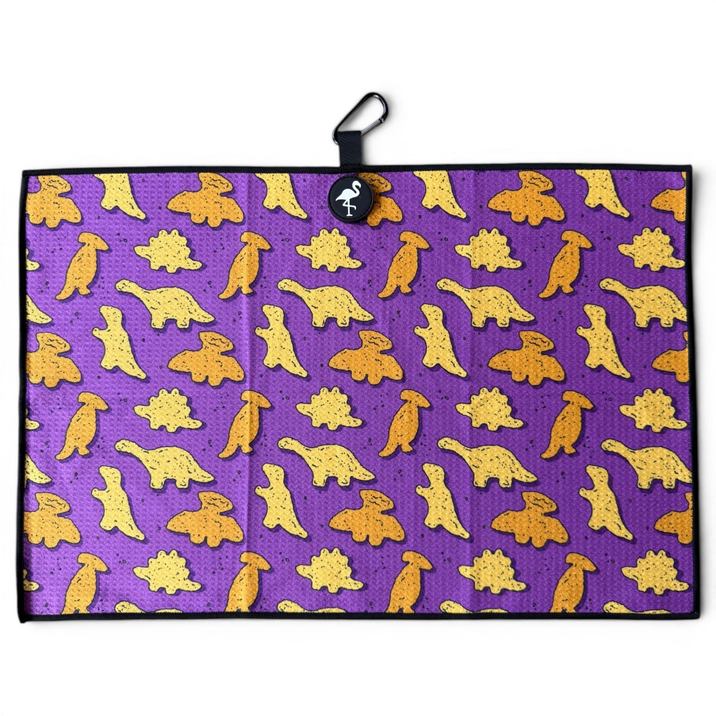 The Purple Dino Chicken Nugget Golf Towel (24” x 16”) features yellow and orange cartoon dinosaurs on a purple microfiber towel with black border, hanging loop, magnetic clip, and carabiner—a stylish premium accessory for golfers.