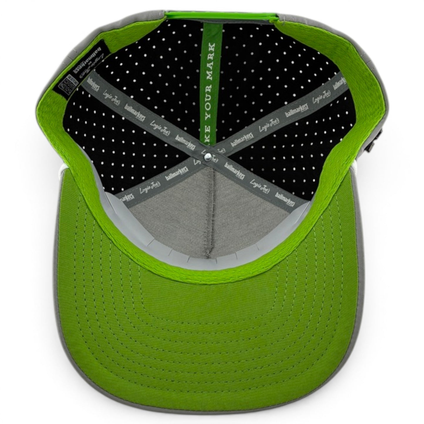 A top-down view of the Alien Caddy Golf Hat shows its gray sweatband with black-and-white branding, polka dots, and a built-in magnetic ball marker holder. The adjustable snapback cap features a green brim with detailed stitching.