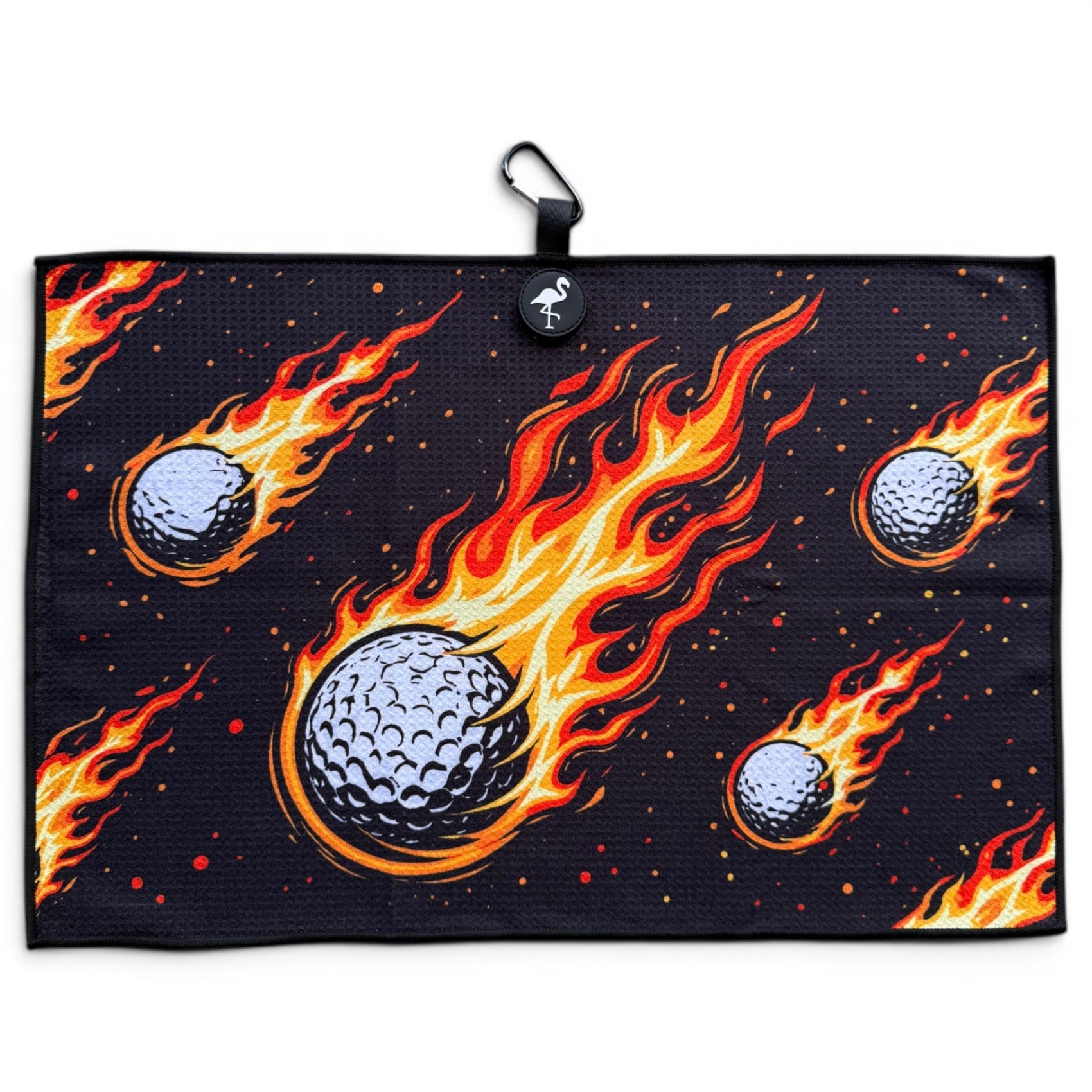 The Fireball Drive Golf Towel (24” x 16”) is a black microfiber golf towel with fiery golf ball graphics, featuring a magnetic clip and carabiner for easy hanging—an ideal premium accessory for golfers.