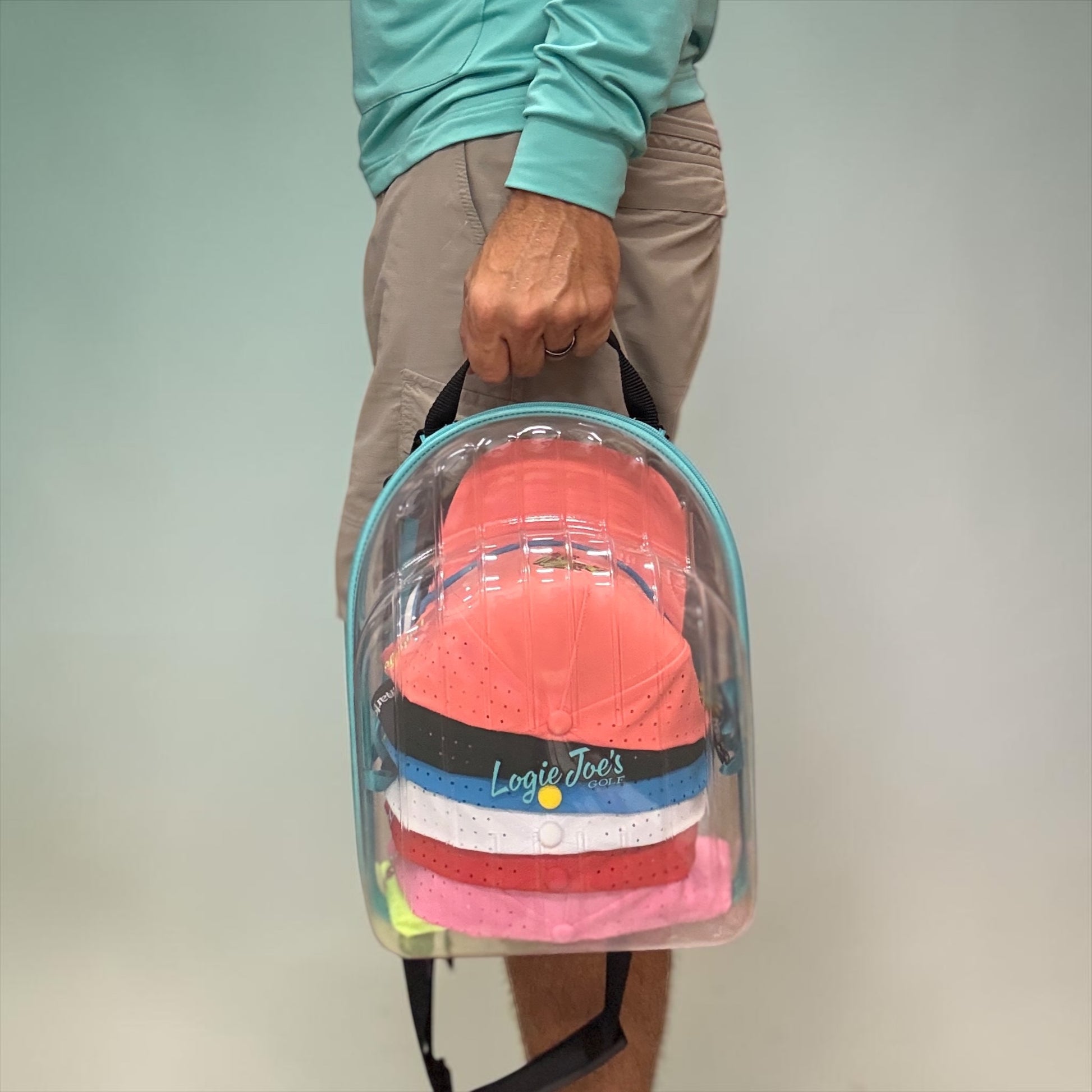 Hat Caddy with clear bag holding colorful hats, featuring text on benefits and uses. travel, hat case, hat caddy, travel gear, hat storage, hat organizer, airport, golf, golf accessories, baseball caps, snapback, trucker hats, gift