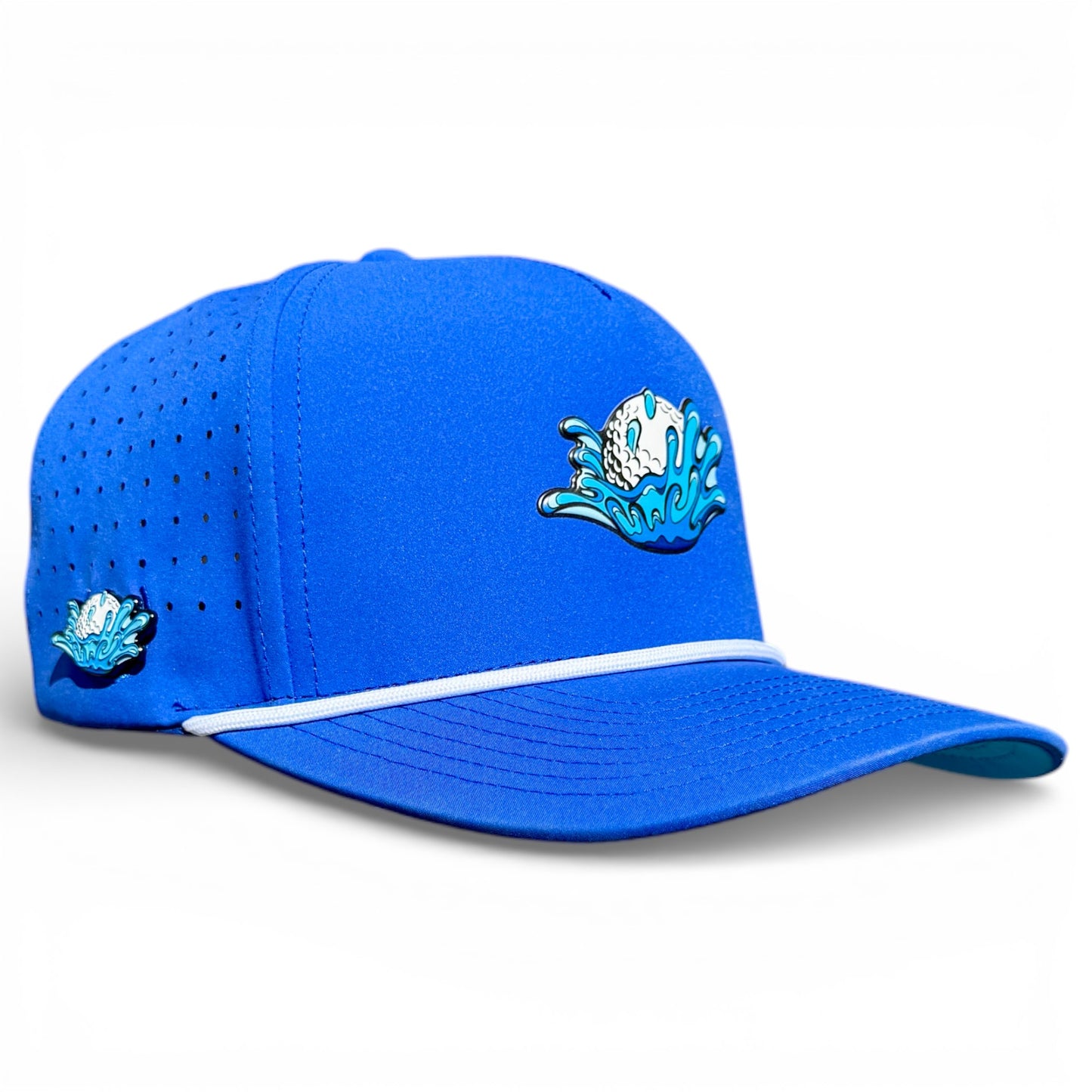 The Water Ball Golf Hat is a bright blue adjustable snapback cap with ventilation holes, a patch of a golf ball splashing into water, white cord detail above the brim, and features a built-in magnetic ball marker holder plus marker.