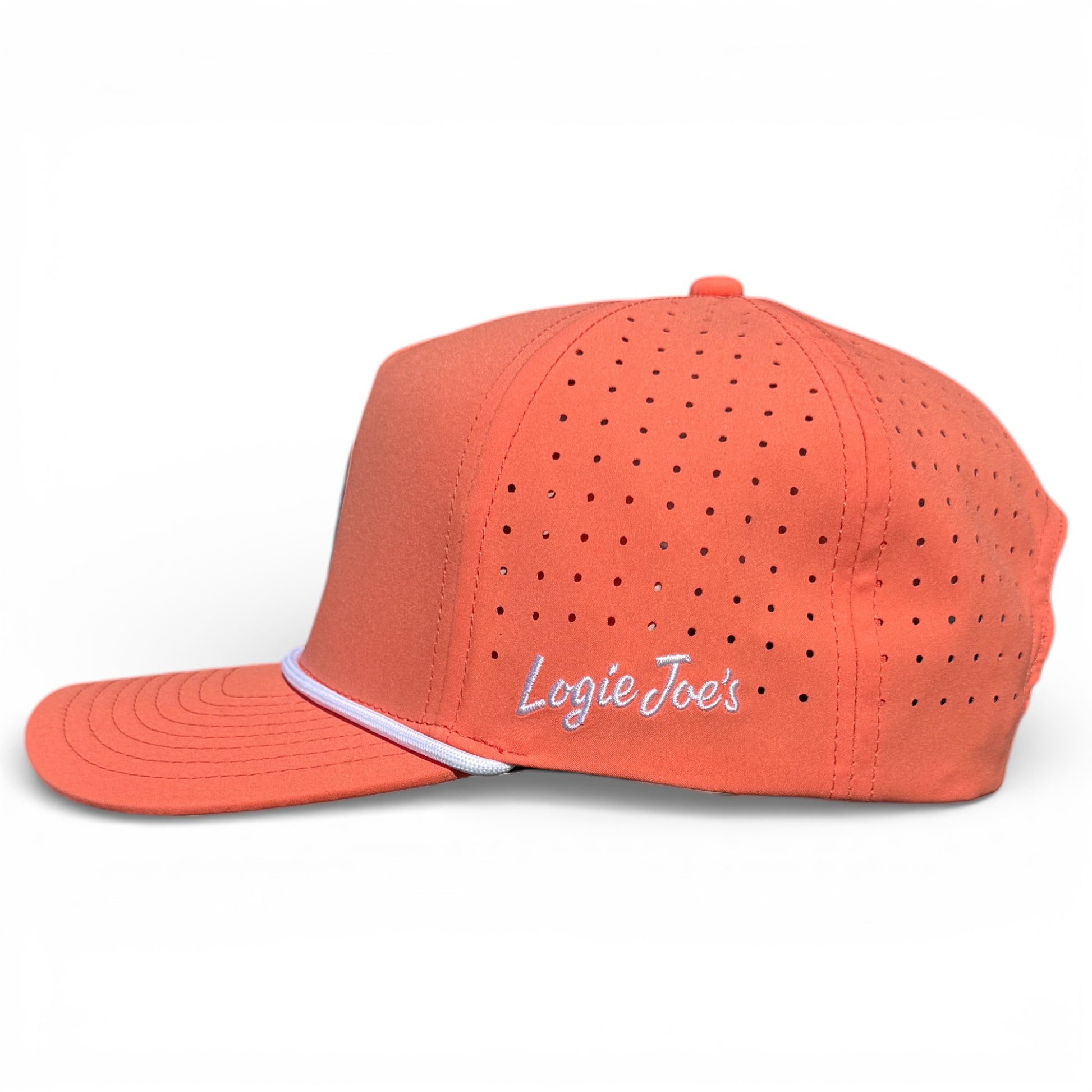 The Just Peachy Golf Hat is a coral snapback cap with perforated sides, "Logie Joes" white script, a curved brim with a white accent line, adjustable fit, and includes a built-in magnetic ball marker holder plus marker.