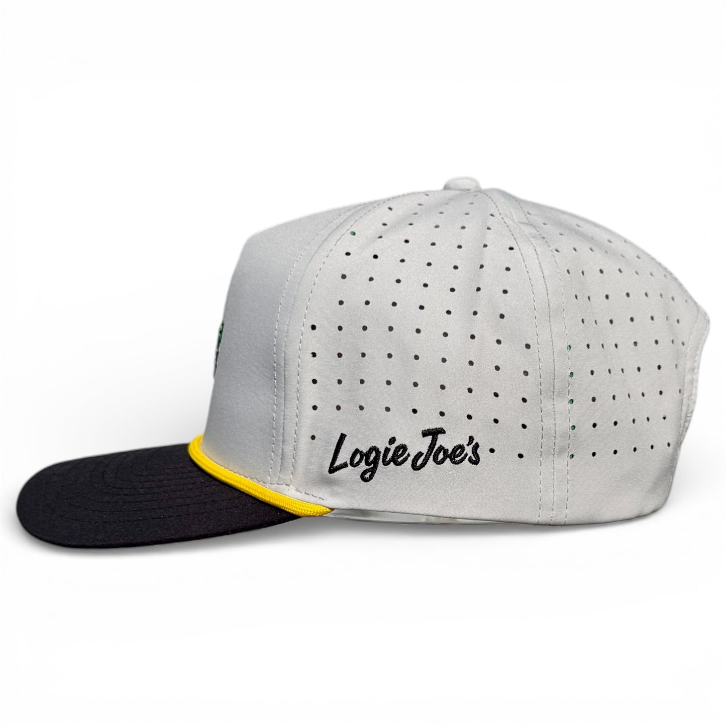 A white Banana Hammock Golf Hat snapback with a black brim, yellow accent above the brim, small black side dots, and “Logie Joe’s” in black script; features built-in magnetic ball marker holder with marker and adjustable fit.