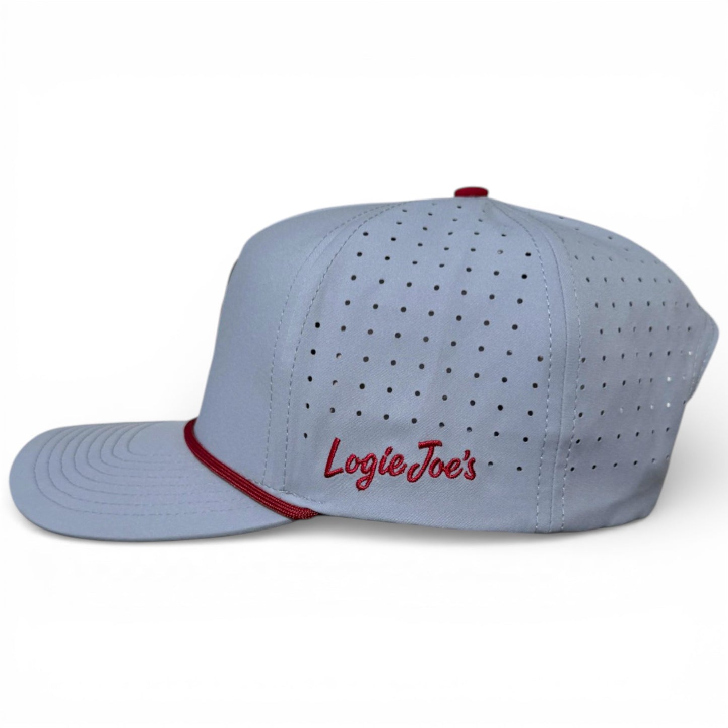 The Transfusion Golf Hat is an adjustable light gray snapback cap with small ventilation holes, a curved bill, bold red stripe above the bill, Logie Joe’s embroidered in red on the side, and includes a magnetic ball marker holder plus marker.