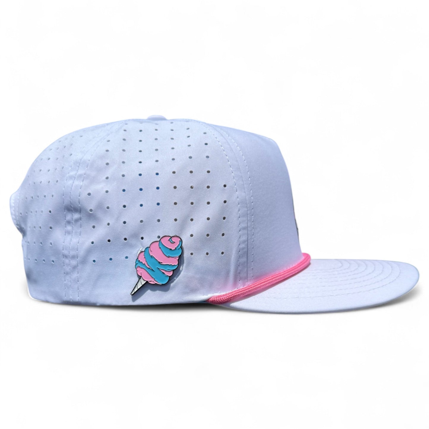 The Sugar Rush Golf Hat is a light blue snapback cap featuring small grey dots, pink trim above the brim, and a colorful cotton candy pin. It has an adjustable fit and includes a built-in magnetic ball marker holder with marker. Left side view shown on white background.