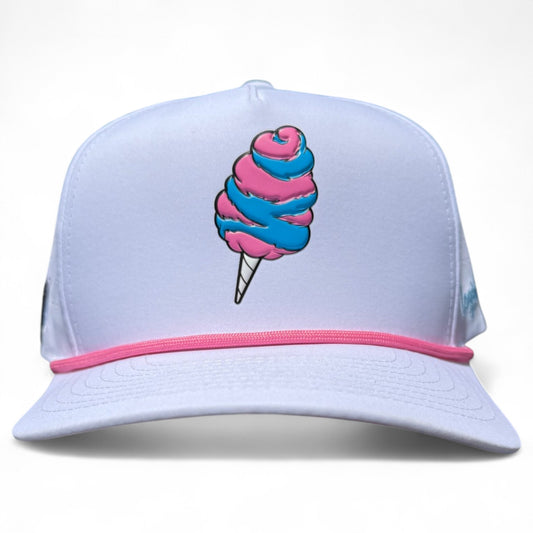 The Sugar Rush Golf Hat is a white snapback with pink trim, blue and pink cotton candy graphic, adjustable fit, and built-in magnetic ball marker holder (marker included). Fun and practical for sunny golf days.