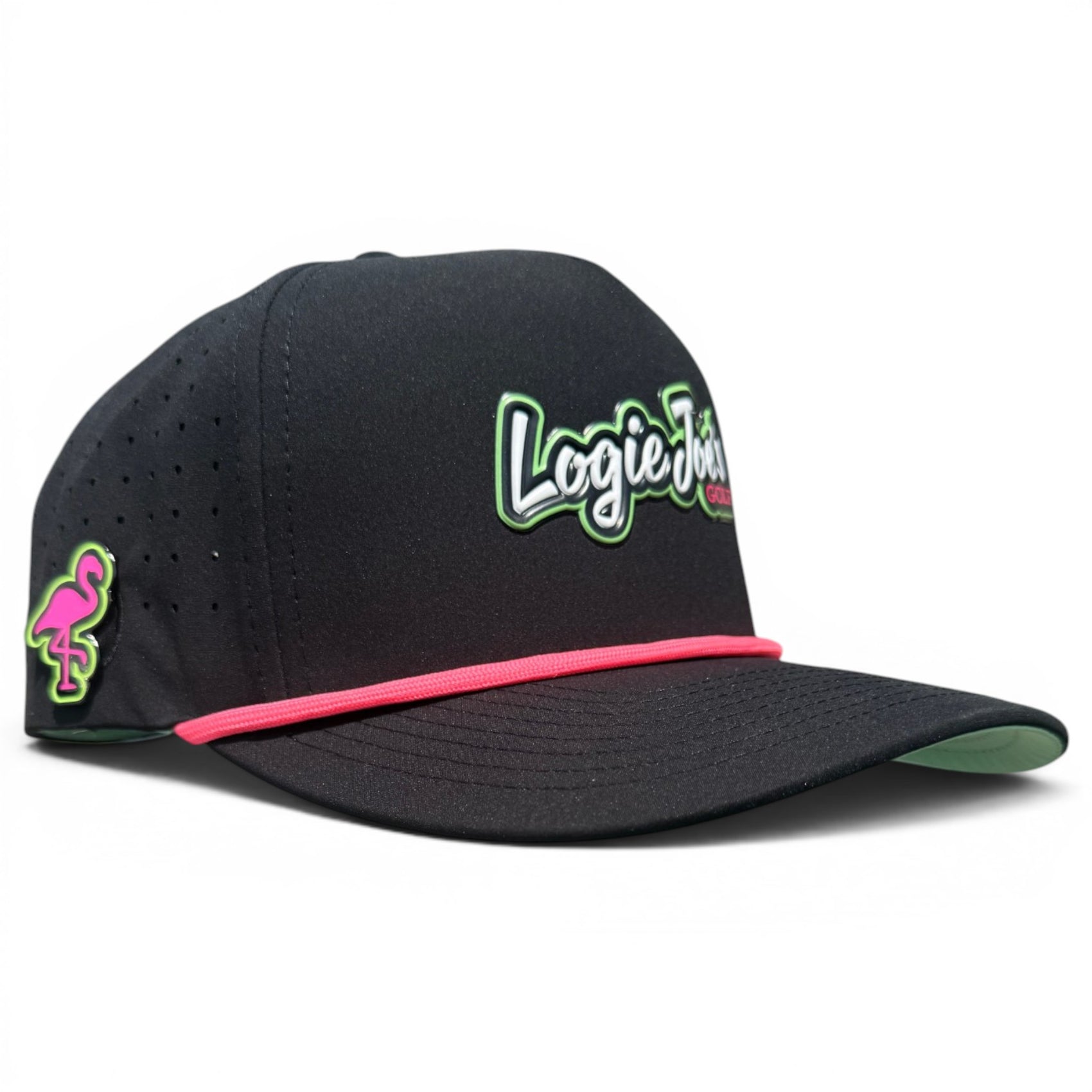The Logie Joe’s "Classic" Golf Hat is a black snapback cap with an adjustable script logo in white and green, a pink flamingo patch on the side, a pink accent rope above the brim, and includes a built-in magnetic ball marker holder with marker.