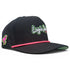 The Logie Joe’s "Classic" Golf Hat is a black snapback cap with an adjustable script logo in white and green, a pink flamingo patch on the side, a pink accent rope above the brim, and includes a built-in magnetic ball marker holder with marker.