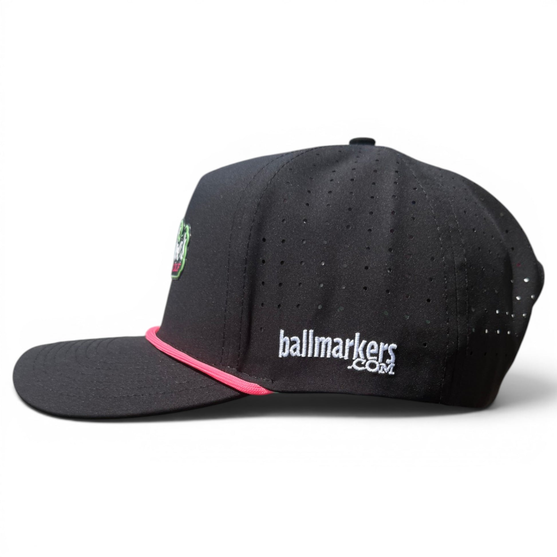 The Logie Joe’s "Classic" Golf Hat is a black snapback cap with pink accent above the brim, perforations, and an adjustable fit. Features a built-in magnetic ball marker holder plus marker, and has the script logo embroidered in white on the side. Plain white background.