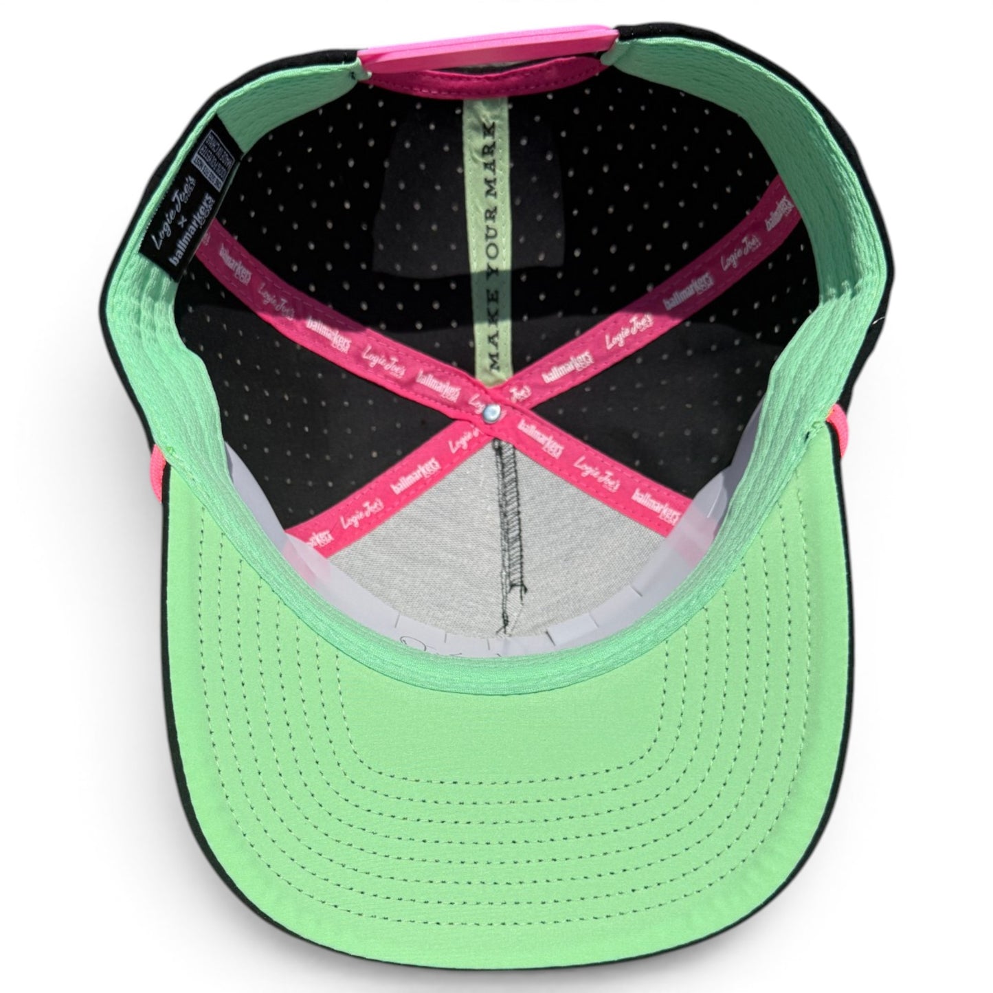 Inside view of Logie Joe’s "Classic" Golf Hat: mint green brim, black interior with white polka dots, pink elastic bands, and an adjustable mint green sweatband. Features a built-in magnetic ball marker holder with marker included.