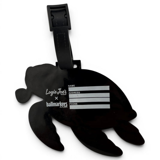The Salty Turtle Clip-On Tag is a black turtle-shaped bag tag with a writable area for your info, sturdy strap, and white Logie Joes text. It’s ideal as a multi-use bag tag, travel tag, or unique golf accessory.