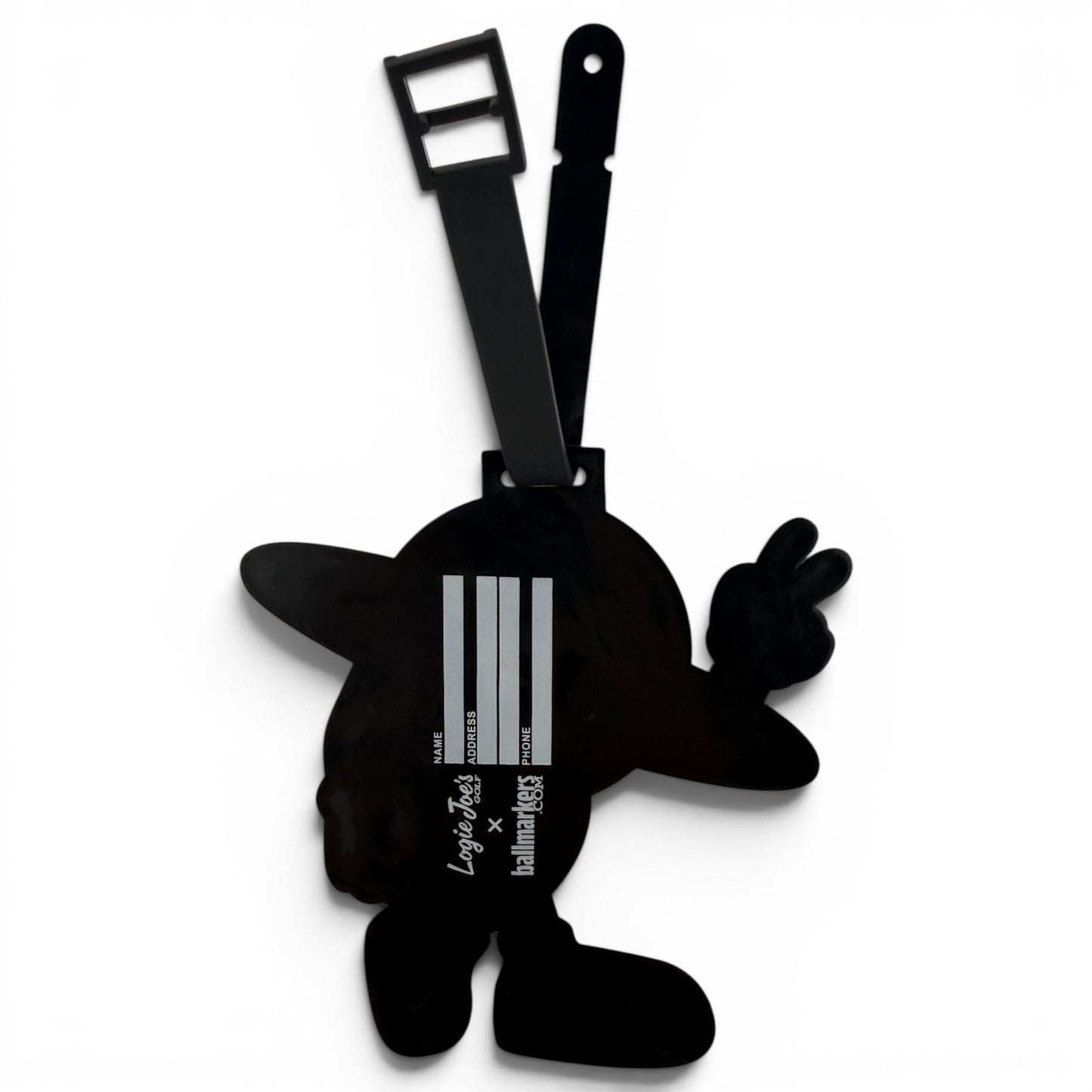 The Saturn Out Clip-On Tag is a black bag tag shaped like a cartoon character with outstretched arms and a hat. It features a strap, barcode-inspired white lines, and printed text on the front—ideal as a multi-use travel or golf accessory.