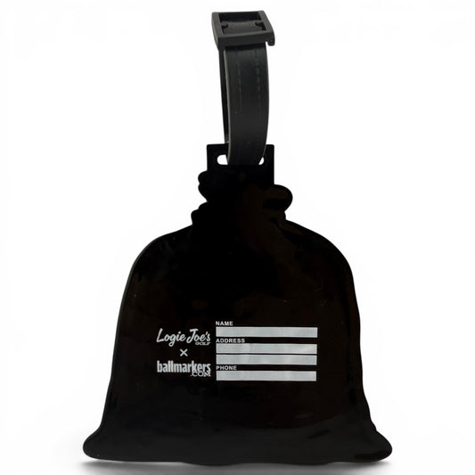 A black Sand Bag Clip-On Tag with a strap, featuring white name, address, and phone fields. This multi-use bag tag is a travel and golf accessory by Logie Joes x ballmarkers.