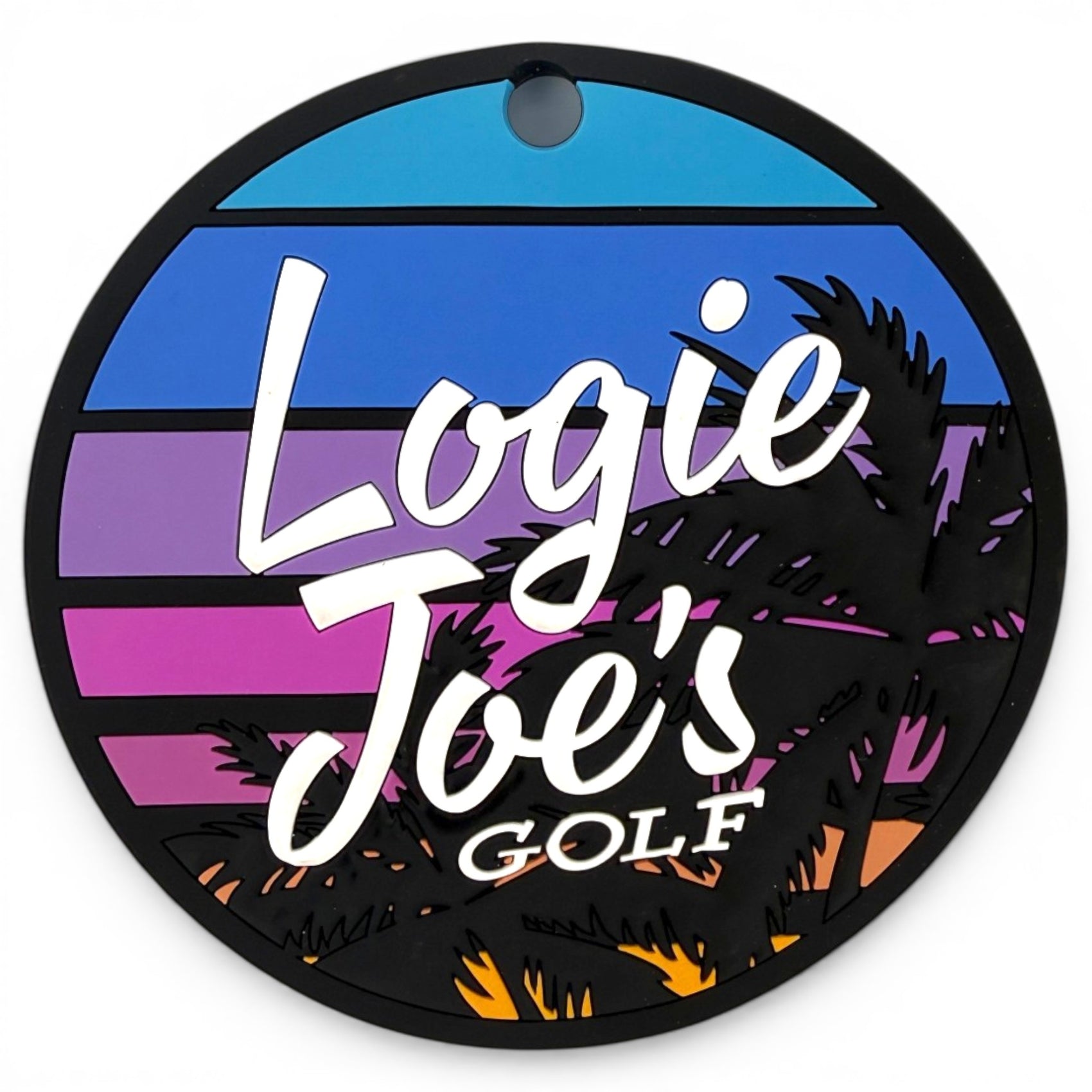 The Sunset Palms Golf Putting Disc features a blue, purple, and orange sunset with palm silhouettes and "Logie Joes Golf" in white script. It has a top hole for attachment, making this indoor practice marker a portable golf training aid.