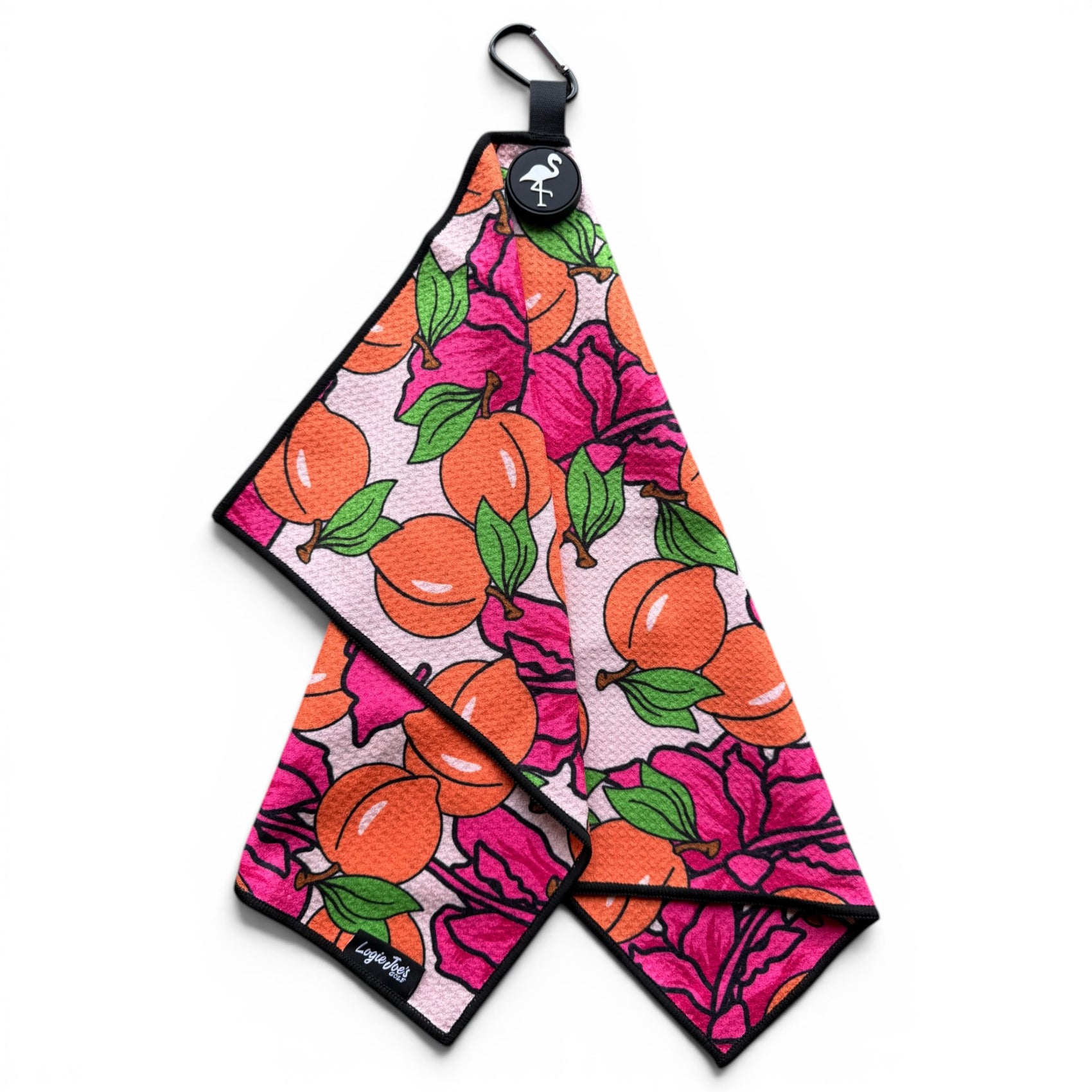 The Peach Bellini Golf Towel (24” x 16”) is a vibrant microfiber towel with orange fruit, green leaves, and pink flower patterns. It features black edges plus a magnetic clip and carabiner for easy hanging—an essential premium golf accessory.