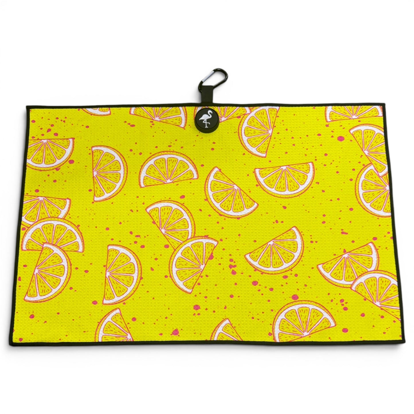 The Main Squeeze Golf Towel is a 24” x 16” yellow microfiber towel with illustrated lemon slices, pink splatters, black border, and comes with a magnetic clip and carabiner—perfect as a premium golf accessory.