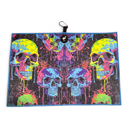 The Neon Skull Golf Towel features vibrant neon skulls with dripping paint on black, measures 24 x 16 in, and is crafted from premium double-sided microfiber. Includes a heavy-duty magnetic design and carabiner clip for easy attachment.
