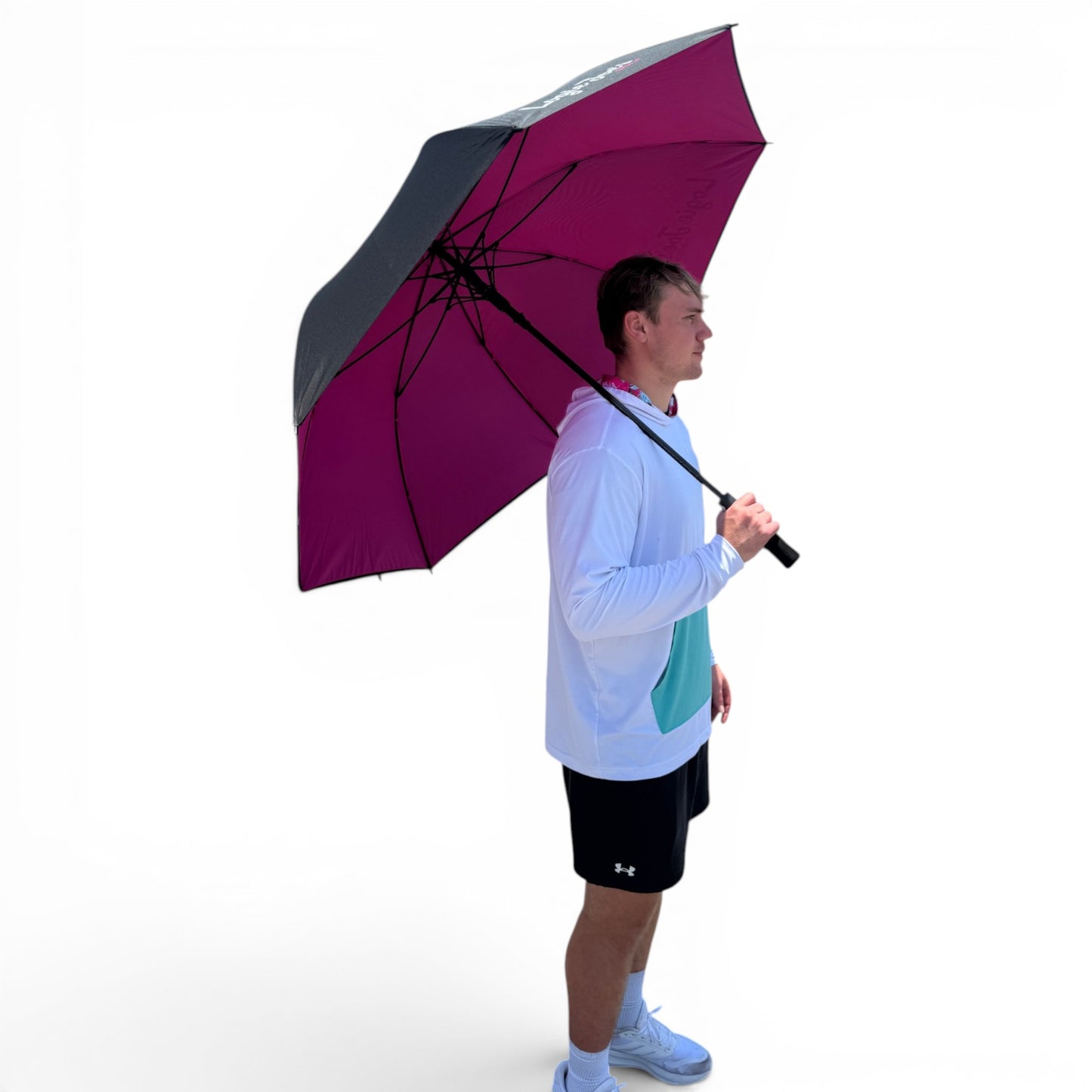 A man in athletic clothing holds the 60" Golf Umbrella | Oversized Black & Pink Golf Umbrella over his shoulder against a plain white background, demonstrating its large coverage and dependable rain protection.