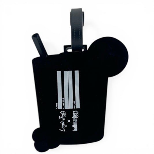 The Transfusion Clip-On Tag is a black bag tag shaped like a bubble tea cup with straw and pearls, white lines for contact info, and features Logo Fiesta and hallmarkers logos. Perfect as a travel, golf, or multi-use bag accessory.
