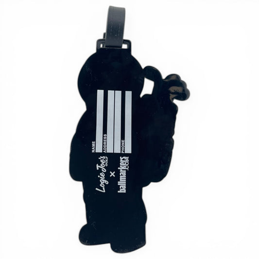 The Astronaut Walker Clip-On Tag is a black cartoon-shaped travel tag with fields for name, address, and phone—plus LoyalTees and PalmTees logos—making it a perfect multi-use bag tag and golf accessory.