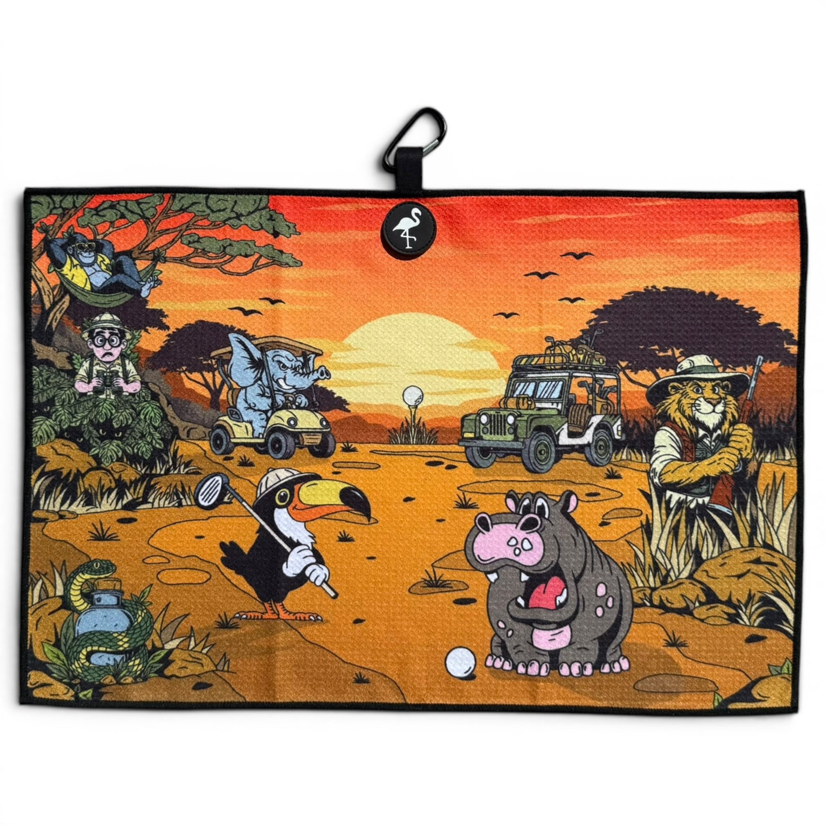A playful African savanna scene features animals golfing at sunset; the lion uses the Safari Expedition: Lost Fairway Golf Towel, a 24"x16" premium microfiber towel with magnetic clip and carabiner, as a jeep rolls by trees in the background.