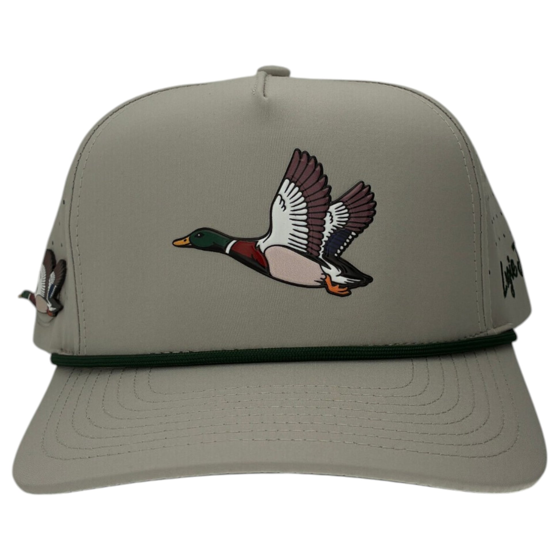 The Mallard Golf Hat is a light gray snapback cap featuring an illustrated flying mallard duck, a dark green cord, and a built-in magnetic ball marker holder with marker included—perfect for your next round. Adjustable for a custom fit.