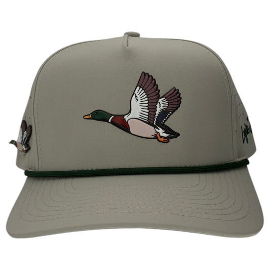 The Mallard Golf Hat is a light gray snapback cap featuring an illustrated flying mallard duck, a dark green cord, and a built-in magnetic ball marker holder with marker included—perfect for your next round. Adjustable for a custom fit.