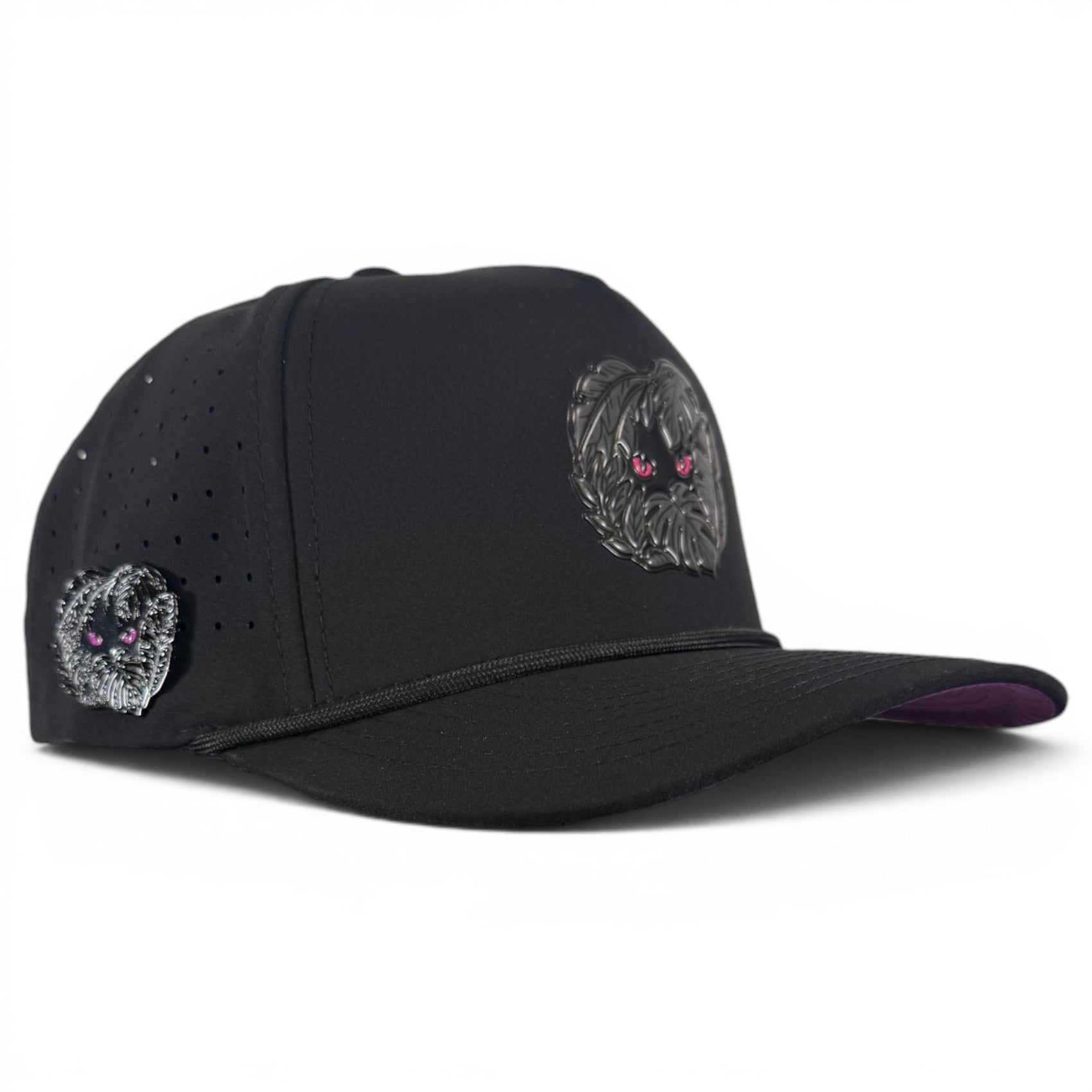 The Night Stalker Golf Hat—an adjustable black snapback cap with animal eyes—features two embroidered dog faces with pink eyes, perforated holes, and a built-in magnetic ball marker holder plus marker on the side panel.