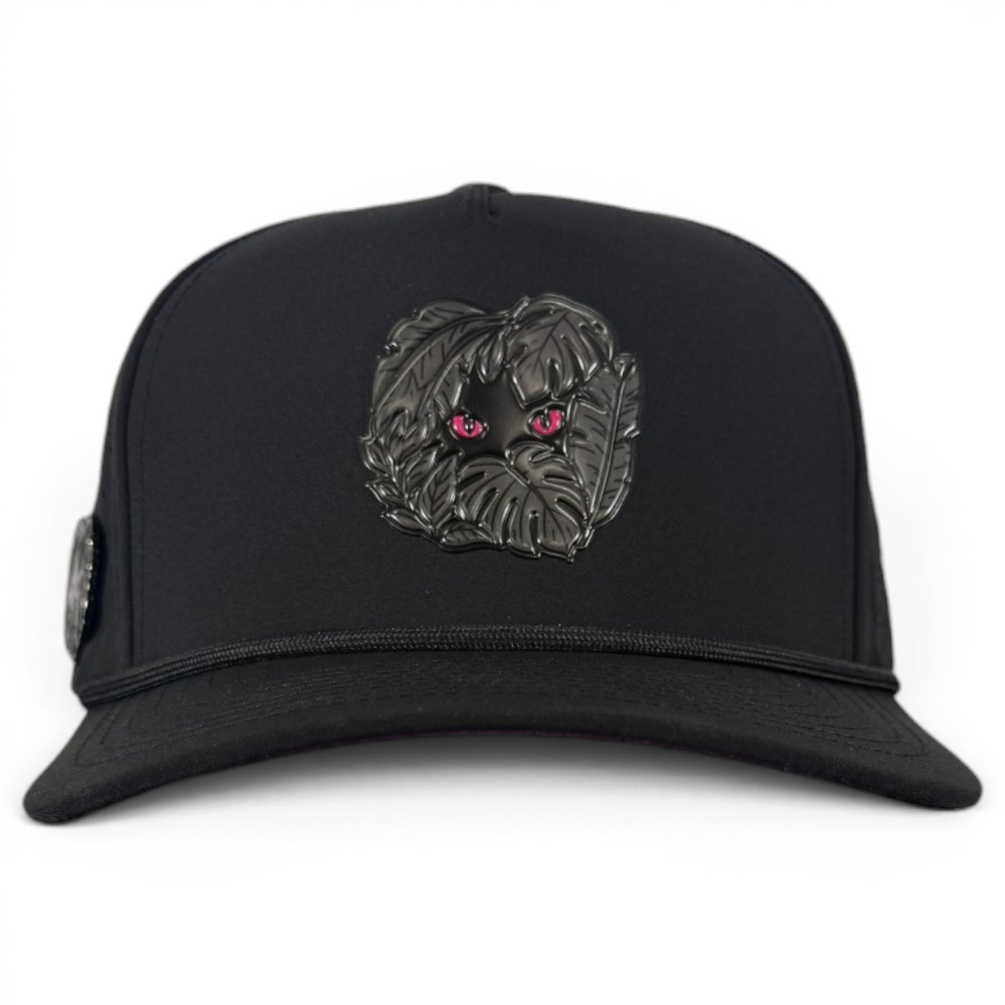 The Night Stalker Golf Hat is a black snapback cap with animal eyes, an adjustable fit, built-in magnetic ball marker holder with marker included, and stylish detailing for golfers.