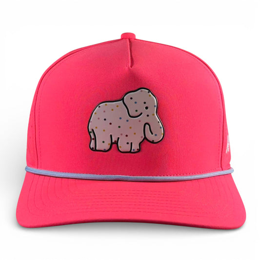 The Frosted Elephant Golf Hat in Elephant Cookie Pink is a snapback cap featuring a cartoon elephant patch, light blue trim, an adjustable fit, and a built-in magnetic ball marker holder with included marker—fun and unique golfer accessory!.
