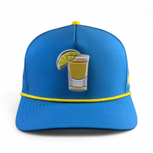 The Tequila and Lime Golf Hat is a blue adjustable snapback cap with yellow trim, a shot glass patch, and a built-in magnetic ball marker holder plus marker—fun, functional headwear for your next round or celebration.