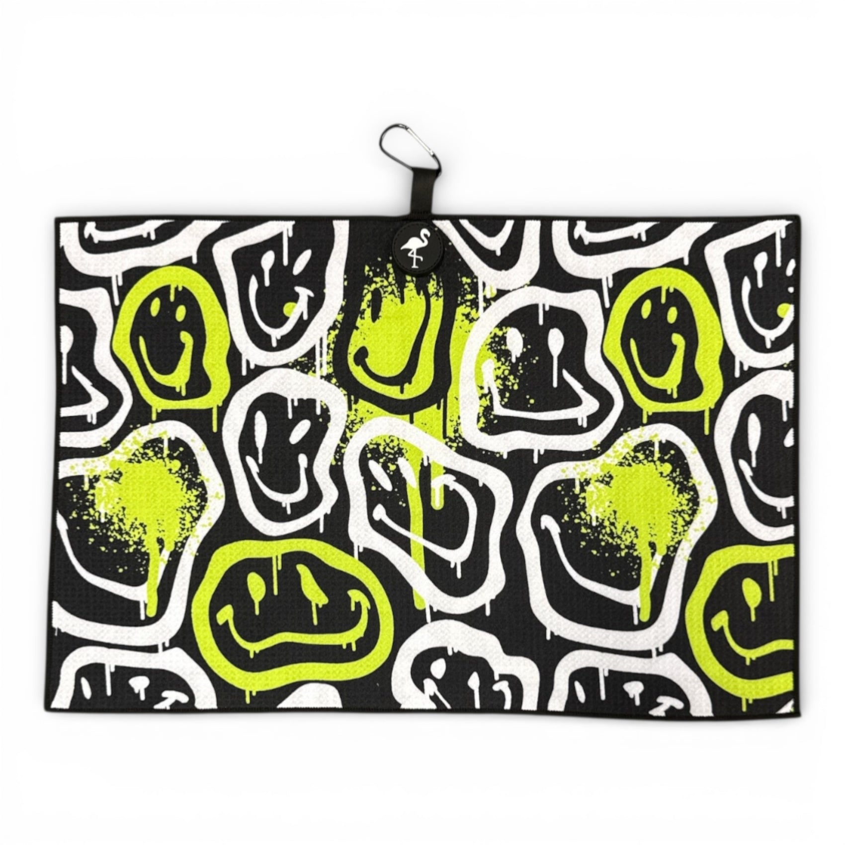 The Drippy Smile Golf Towel (24x16 in) features abstract white and neon yellow drippy smile faces on a black microfiber backdrop, paint splatter accents, and includes a heavy-duty magnetic back plus carabiner clip for easy access.