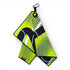 The Neon Current Golf Towel is a 24x16 in double-sided microfiber towel in yellow, black, blue, and white with bold geometric and dotted patterns. Features include a carabiner clip, heavy-duty magnet, and a flamingo tag. Shown hanging on a white background.