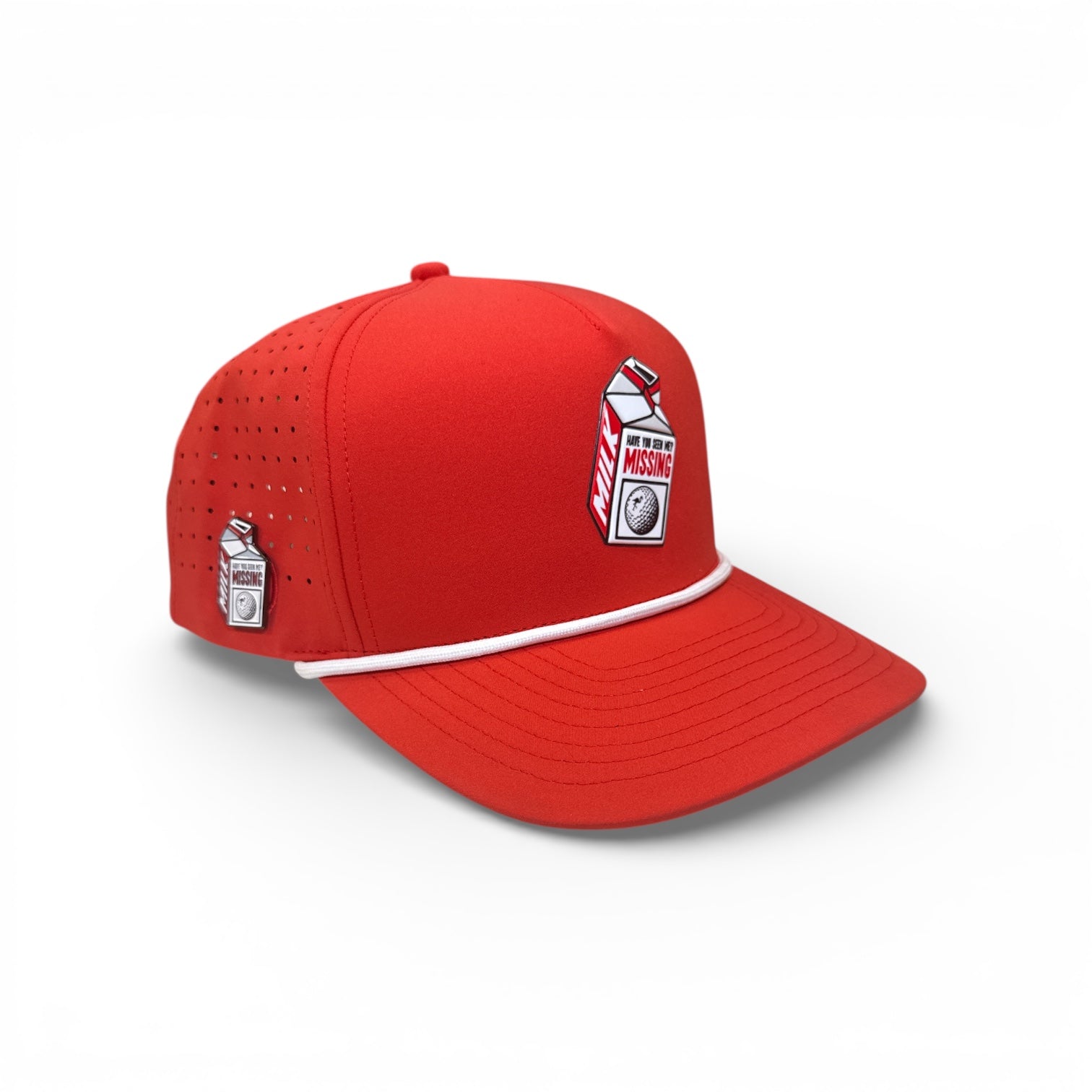 The Missing Milk Golf Hat is a red adjustable snapback cap with a white cord, built-in magnetic ball marker holder (marker included), embroidered milk carton with "Missing" label, side perforations, and is a unique golf accessory.