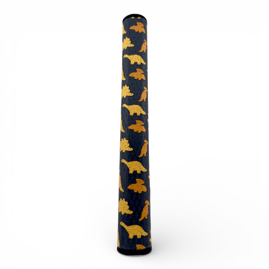 The Dino Nugget Putter Grip 3.0 Tour features premium dark blue PU material and a stable oversize feel, decorated with a repeating pattern of yellow dinosaur nuggets on a white background.