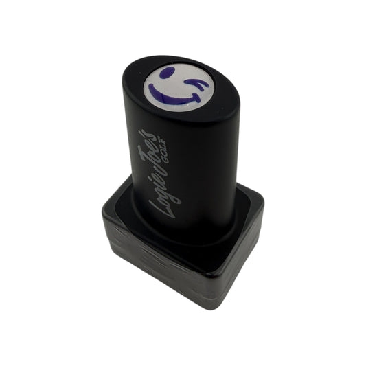 The Winky Face Golf Ball Stamp features quick-dry ink, easy ball identification, and a purple smiley face design—making it a fun golf gift, shown here with 